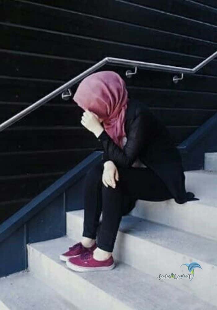صورة بنت محجبة حزينة تجلس على السلم تبكي